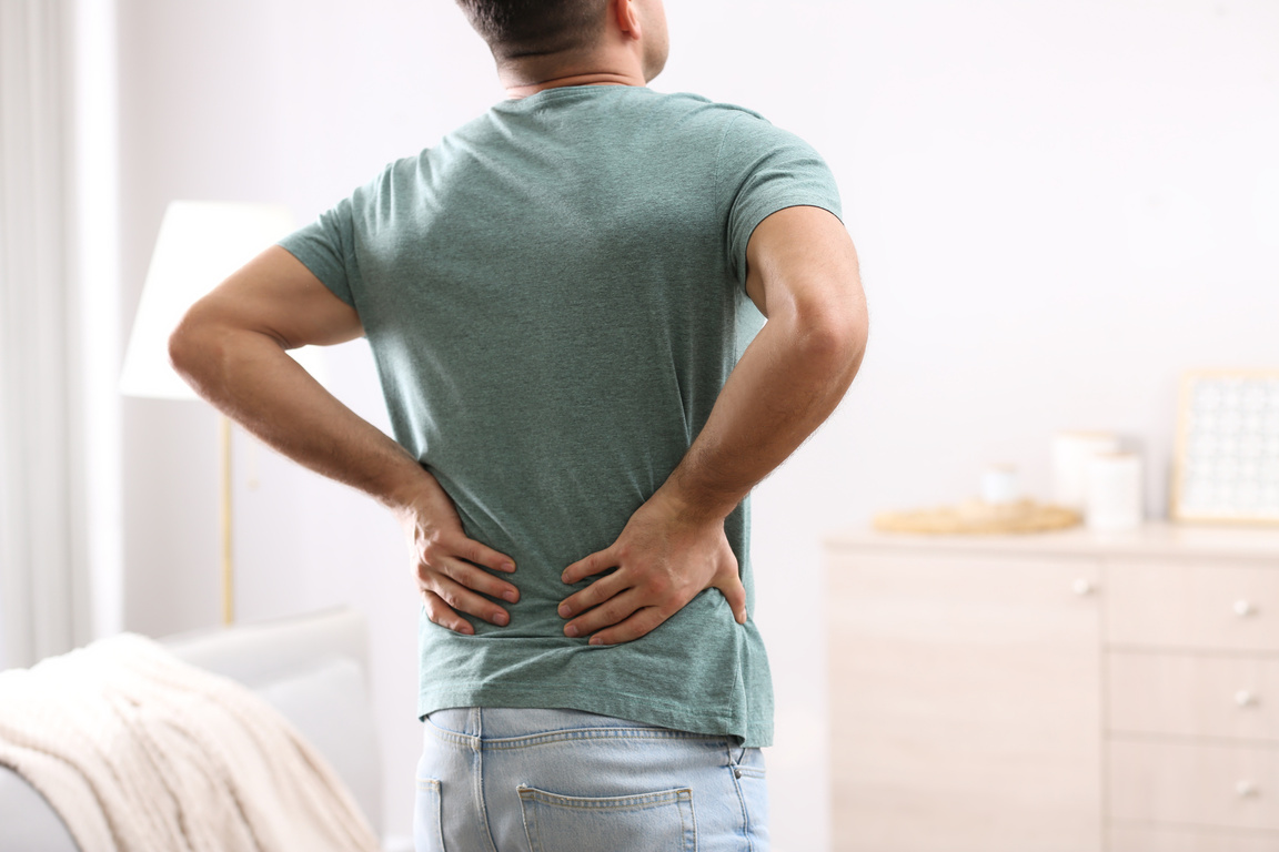 Man Suffering from Back Pain at Home. Bad Posture Problem